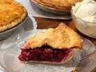 slice of raspberry rhubarb pie, a bowl of ice cream on the side 