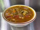 Bowl of Beef Barley Soup, containing beef, pearl barley, mushrooms, carrots, tomatoes, celery, onion, hearty stock. 