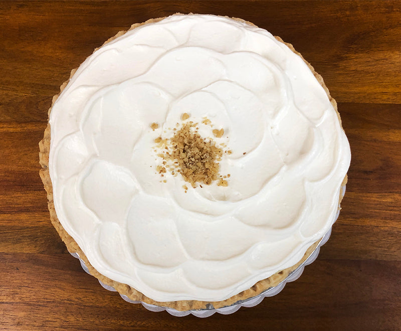 Over head photo of Whole Banana Cream Pie - sliced banana, pastry cream, covered with whipped cream and walnut sprinkles